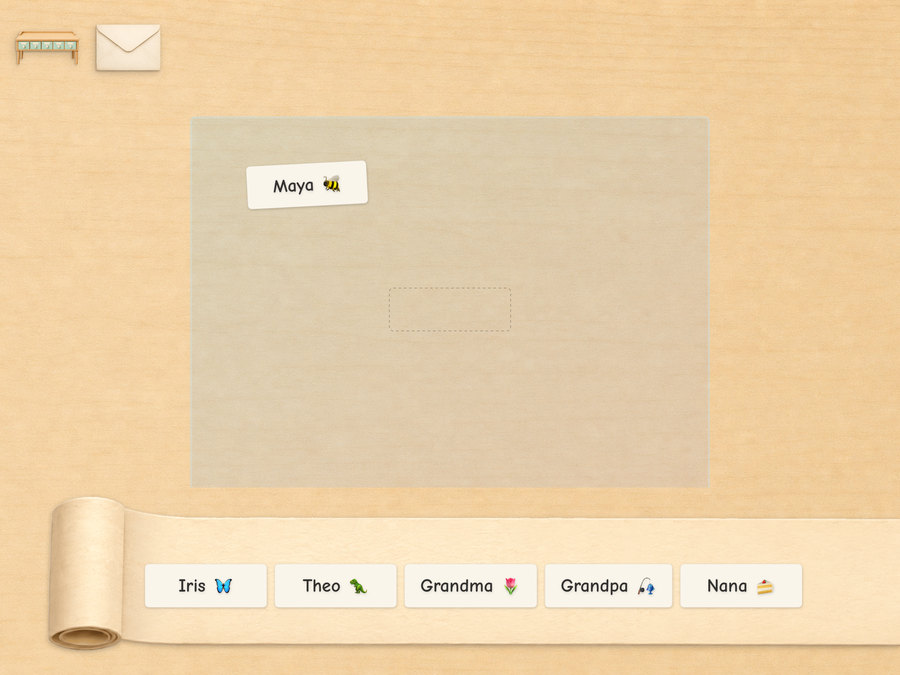 An envelope on the desk carrying a From sticker, with a roll of address labels - Iris, Theo, Grandma, Grandpa, Nana - waiting below
